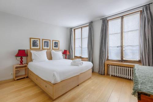 une chambre avec un grand lit et deux fenêtres dans l'établissement Luxury Apartment Saint Honore Champs Elysees, à Paris