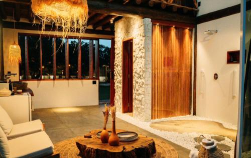a living room with a tree stump table and a room with a couch at Bali Atins in Atins