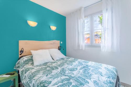 セルベールにあるAppartement 4p - Meu Descanの青い壁と窓のあるベッドのある寝室