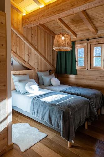 une chambre avec un lit dans une cabane en bois dans l'établissement La Java, à Villard-Reculas