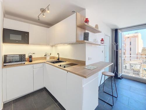 une cuisine blanche avec des armoires blanches et une fenêtre dans l'établissement Nestor&Jeeves - GIOFFREDO BELLO - central - near beach, à Nice