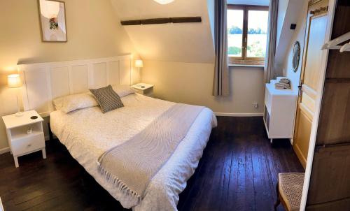 a bedroom with a large bed and a window at Wisteria Gites in Saint-Denis-de-Gastines