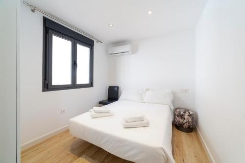 une chambre avec un lit blanc et une fenêtre dans l'établissement TrendyHomes Palmeral Beach Mojacar, à La Marina de la Torre