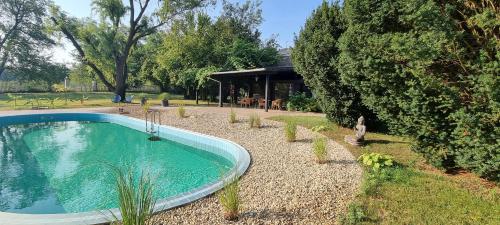 una piscina in un cortile accanto a una casa di Cottage 2 im Natur-Resort Pool, Schwimmteich & Sauna a Kiskunmajsa