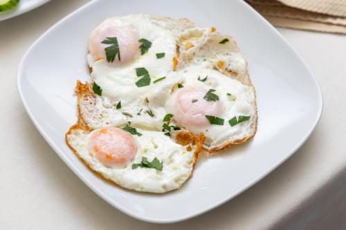 a plate of food with eggs and herbs on it at Hotel Luxor in Pristina