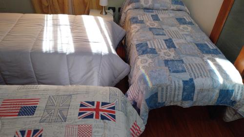 two beds in a hotel room with british flags quilts at Bed & Breakfast Il PIGNOMO in Villar Dora