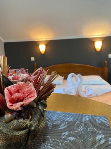 a hotel room with a bed with a table with a flower at Motel Krstac in Mojkovac