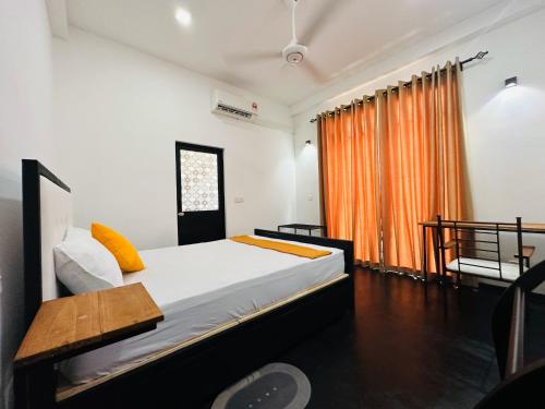 a bedroom with a bed and an orange curtain at Large 4 Bedroom Spacious Apartment in Nugegoda, Colombo in Nugegoda