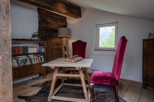 a room with a wooden table and a red chair at Jagerbauerngut in Wimm