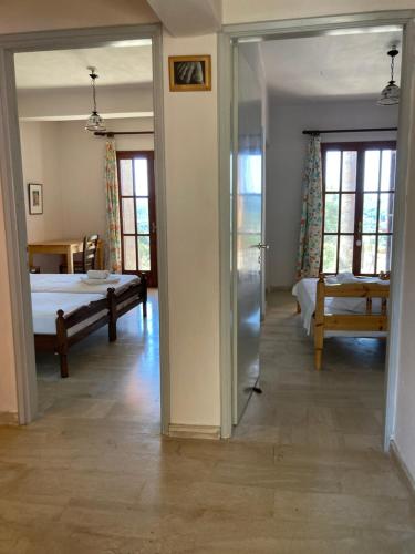 a room with two beds and a door leading to a bedroom at Kokkini Peach Budget in Kokkínion