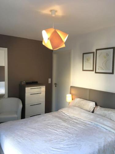 une chambre avec un grand lit et une lampe dans l'établissement Appartement Résidence en rez-de-chaussée Les Jardins de Diane, à Fontainebleau