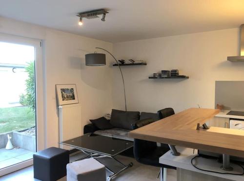 un salon avec une table et un canapé dans l'établissement Appartement Résidence en rez-de-chaussée Les Jardins de Diane, à Fontainebleau