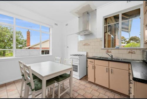 a kitchen with a white table and a white stove top oven at Ashburton Big room for rent in Chadstone