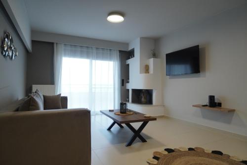 a living room with a couch and a table at SEA LA VIE Apartments & Maisonette in Livanátai