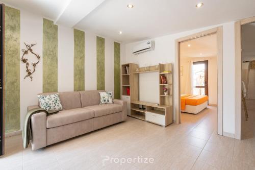 a living room with a couch and a bedroom at Tra I Verdi Pini by Propertize in Capoterra