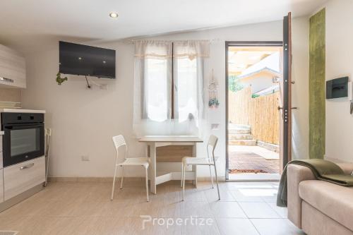 a living room with a table and chairs and a tv at Tra I Verdi Pini by Propertize in Capoterra