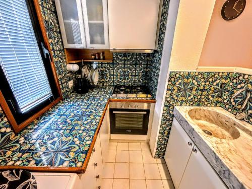 a small kitchen with blue and white tiles at Deluxe Apartament - Marina di Carrara - in Marina di Carrara