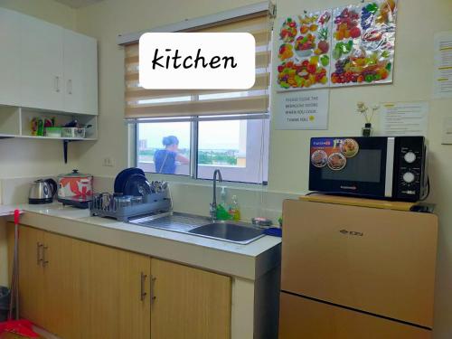 a kitchen with a sink and a microwave on a counter at Two-Bedroom at San Remo Oasis in Cebu City