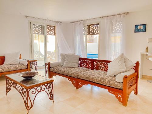 a living room with two couches and a table at Nayah Stays, Amazing villa with private pool & 5 master suites in Hurghada