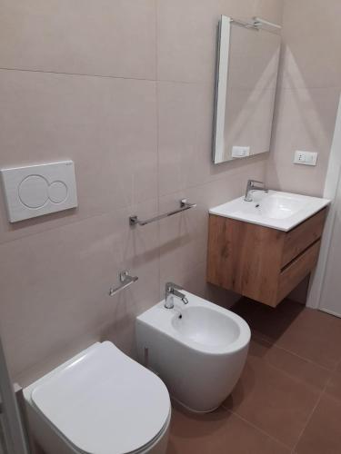 a bathroom with a toilet and a sink and a mirror at Apartment Emanuela in Porto Cesareo