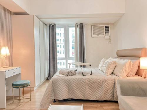 a small bedroom with a bed and a window at Abreeza Place WIFI & Netflix in Davao City