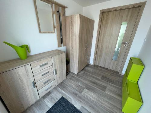 a living room with a green chair and a cabinet at Ubytování v soukromí u Růženky in Podivín