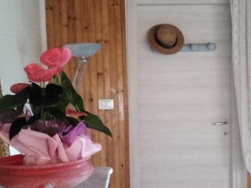 Una pianta in una pentola rossa vicino a una porta di Good Art a Strevi