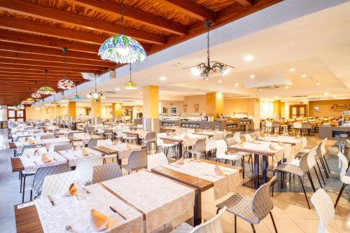 a dining room with tables and chairs and a restaurant at HOVIMA Santa María in Adeje