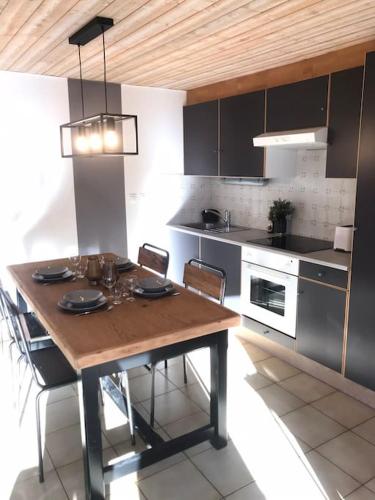 - une cuisine avec une table en bois, des chaises et une cuisinière dans l'établissement Le St Jean, à Saint-Georges-sur-Eure