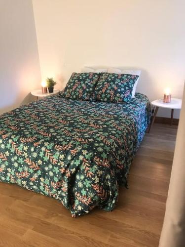 une chambre avec un lit avec une couette fleurie dans l'établissement Le St Jean, à Saint-Georges-sur-Eure