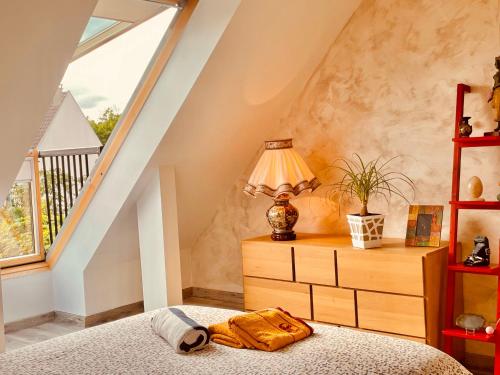 une chambre avec un lit et une lampe sur une commode dans l'établissement Maison Calme et Confort avec Jardin, Face Parc Exposition - Aéroport du Bourget, à 10 min de CDG, au Blanc-Mesnil