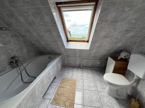 a bathroom with a tub and a toilet and a window at Ośrodek Wypoczynkowy Złote Piaski in Jarosławiec
