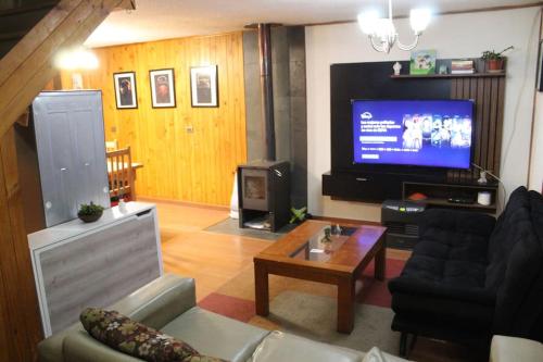 a living room with a couch and a tv at Alojamiento Casa completa en Puerto Montt in Puerto Montt