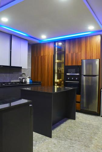 a kitchen with a black counter and a refrigerator at The Blanche Apartment in Aso