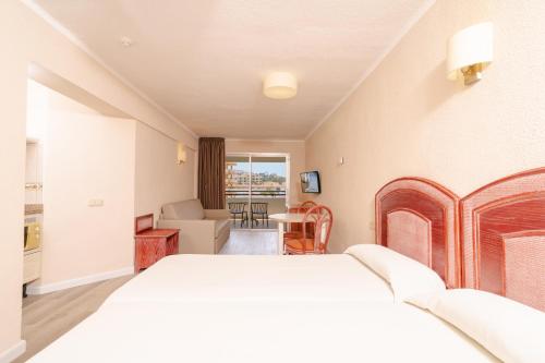 a bedroom with a bed and a living room at HOVIMA Santa María in Adeje