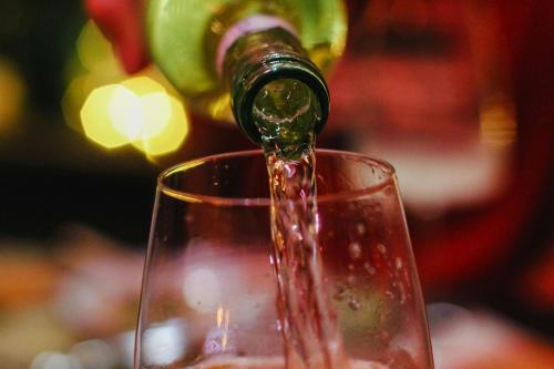 a bottle of wine being poured into a wine glass at Kona Hotel Verona by Kleos Group Collection in Negrar