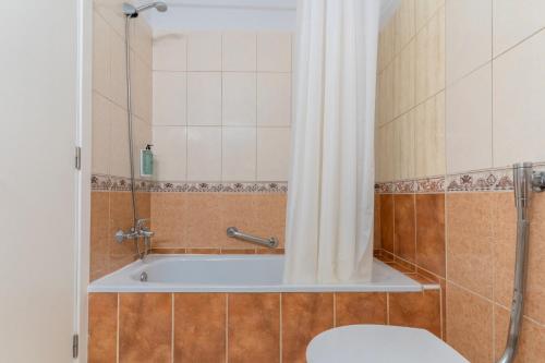 a bathroom with a tub with a toilet and a shower at HOVIMA Santa María in Adeje