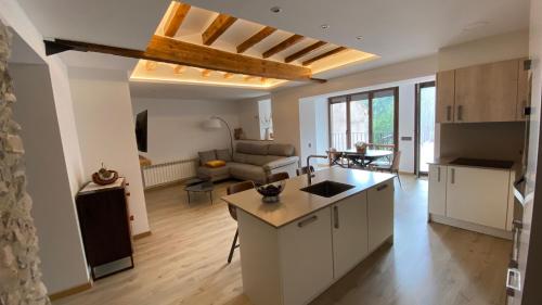 an open kitchen and living room with a couch at Pis turístic de 170 m2 a la plaça Porxada de Bagà in Bagá