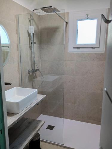 une salle de bain avec une douche et un lavabo et un lavabo dans l'établissement Rez de jardin lumineux à 100m de la mer, à Valras-Plage