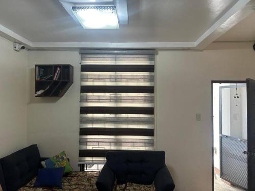 a living room with a couch and a window at Nasugbu or Tuy - Entire House at RCD Royale Homes in Tuy