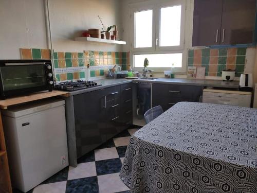 une cuisine avec une table et une cuisinière four supérieur dans l'établissement Location Appartement sympa, à Aulnay-sous-Bois