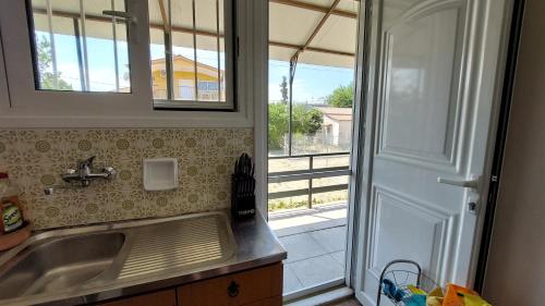 a kitchen with a sink and a window at Nadina's house in Dhílesi