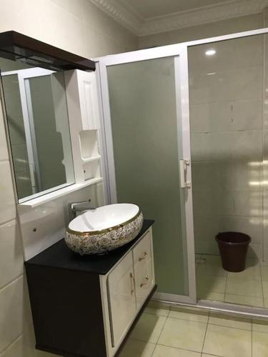 a bathroom with a sink and a mirror at Serene 2 bed with Wi-Fi and AC in Madina