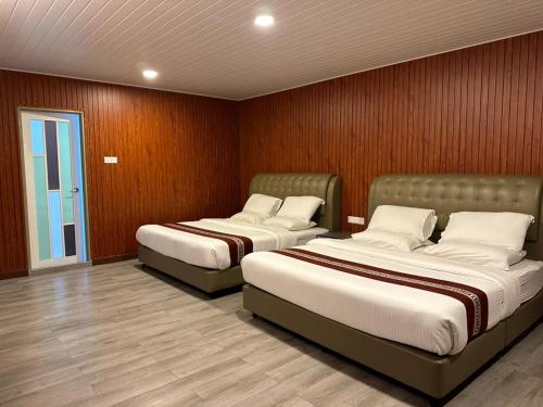 スレンバンにあるSS Hotel Serembanのベッド2台 木製の壁の部屋
