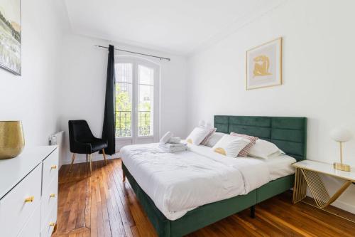 une chambre avec un grand lit avec une tête de lit verte dans l'établissement 2 pieces fonctionnel metro Jaures - Paris 19 - 4p - FLAT-GUEST, à Paris