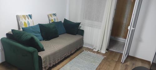 a green couch in a room with a window at Zamfira Home in Tulcea