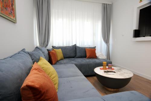 a living room with a blue couch and a table at Venima City Center Apartment in Tivat