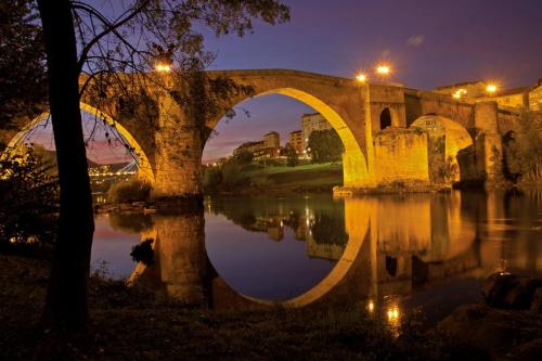 an old bridge over a river at night at Piso Estación Termal GARAJE Y AIRE ACONDICIONADO in Ourense
