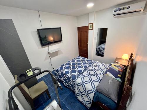 a small bedroom with a bed and a tv at Departamento Master - 4 minutos Consulado Americano - Guayaquil in Guayaquil