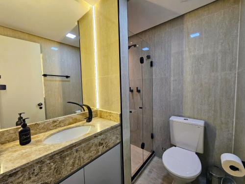 a bathroom with a sink and a toilet and a mirror at Mercure Recife Navegantes - Privado in Recife